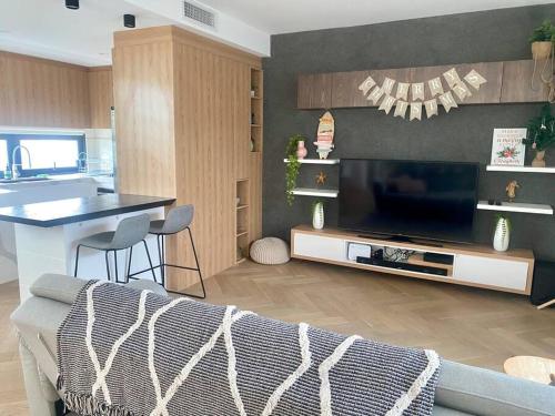uma cozinha e uma sala de estar com uma televisão e um sofá em Casa De Mork - Entire 3 Storey Beach Villa em Gold Coast