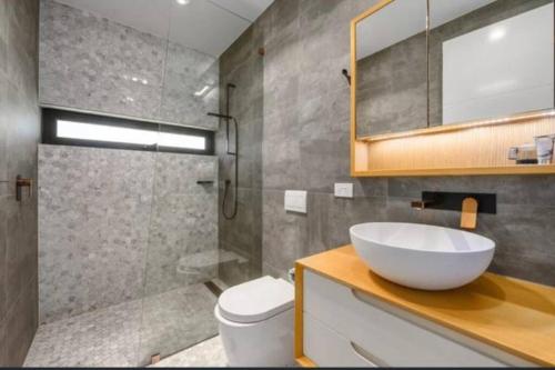 y baño con lavabo, aseo y ducha. en Casa De Mork - Entire 3 Storey Beach Villa en Gold Coast
