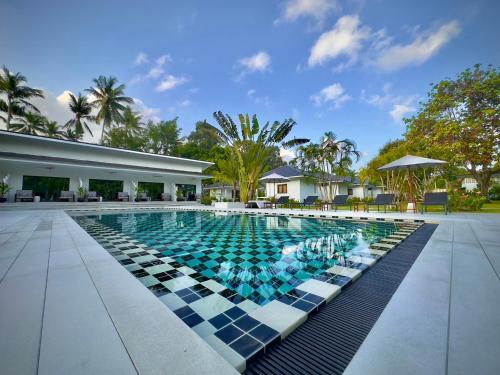 une piscine avec un sol en damier et un bâtiment dans l'établissement Moorea Boutique Resort Samui, à Koh Samui 