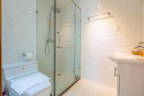 a bathroom with a shower and a toilet and a sink at Léman Luxury Apartment District 3 HCMC in Ho Chi Minh City