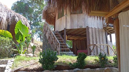 una escalera que conduce a una casa con techo de paja en ECOCABAÑAS DIOSA JAGUAR tayrona, en Santa Marta