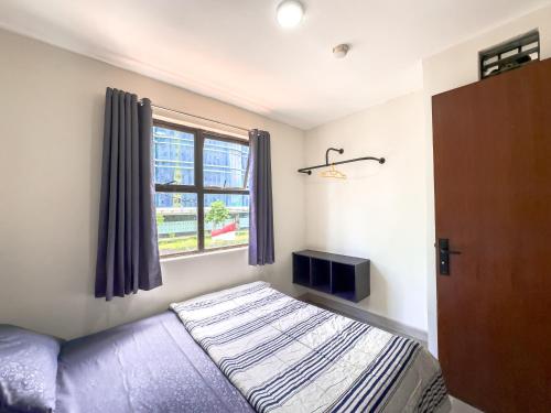 a bedroom with a bed and a window at Beranda Istirahat 2BR Laguna Pluit in Jakarta