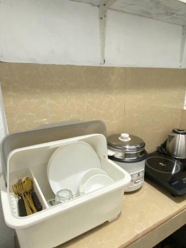un conteneur blanc est assis sur un comptoir de cuisine dans l'établissement Staycation in Imus Near Robinson, à Imus