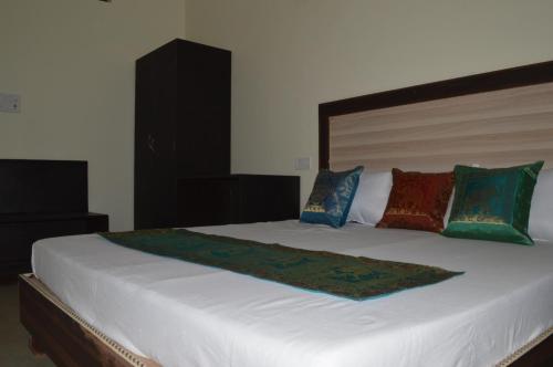 a large white bed with pillows on top of it at Hotel Plaza_Khajuraho in Khajurāho