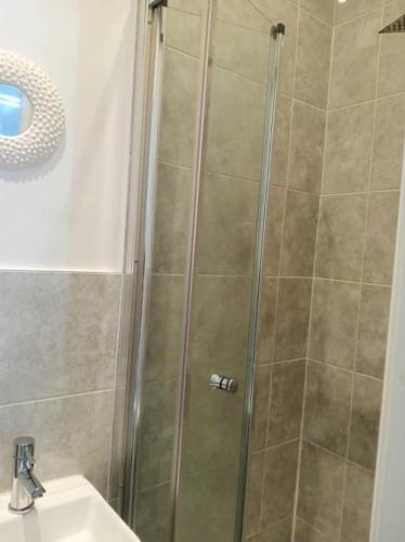 eine Dusche mit Glastür neben einem Waschbecken in der Unterkunft Ensuite Double-bed (G3) close to Burnley city centre in Burnley