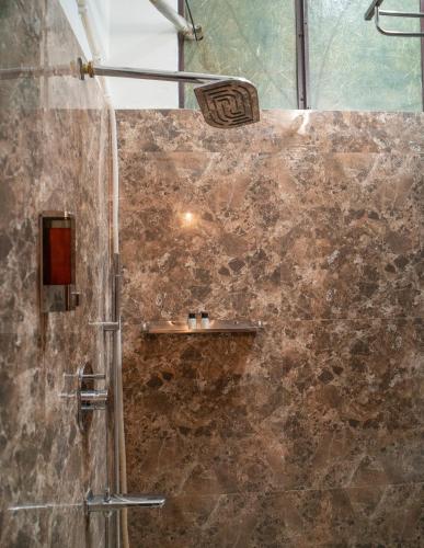 a bathroom with a shower with a stone wall at Soham Haveli Udaipur in Udaipur