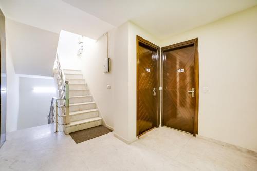 a staircase in a house with a glass door at OYO Hotel Carol Garden in New Delhi