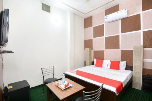 een kamer met een bed, een tafel en een televisie bij Super OYO Urban Guest House in Patiala