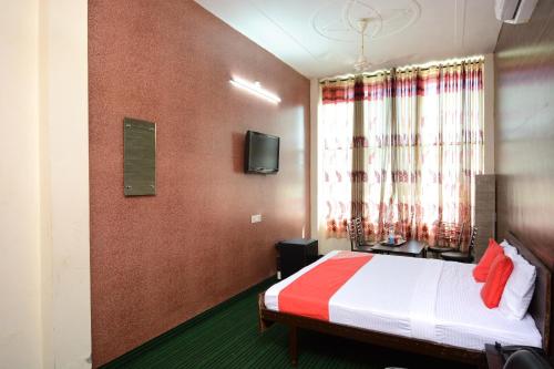 a hotel room with a bed and a window at Super OYO Urban Guest House in Patiāla