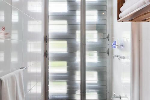 uma casa de banho com um chuveiro e uma porta de vidro em Casa de Piedra Tulum em Tulum