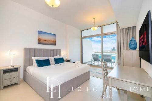 een slaapkamer met een bed, een bureau en een balkon bij LUX Opulent Island Suite Burj Khalifa View 7 in Dubai