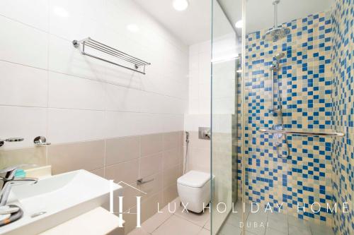 een badkamer met een douche, een toilet en een wastafel bij LUX Opulent Island Suite Burj Khalifa View 7 in Dubai