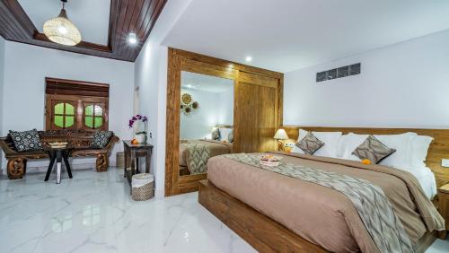 a bedroom with a bed and a desk in it at Kirani Joglo Villa Bali by Mahaputra in Sukawati