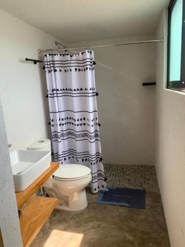 a bathroom with a toilet and a shower curtain at PortalM in Malinalco