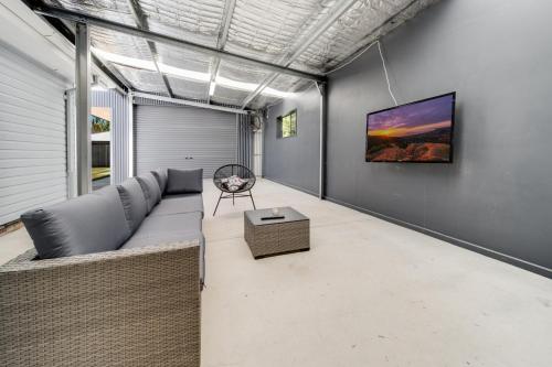 a living room with a couch and a tv on a wall at Spacious 4-bed Family Home in Tranquil Setting in Canberra