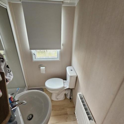 małą łazienkę z toaletą i umywalką w obiekcie 2BEDROOMEVIE w mieście Rhyl
