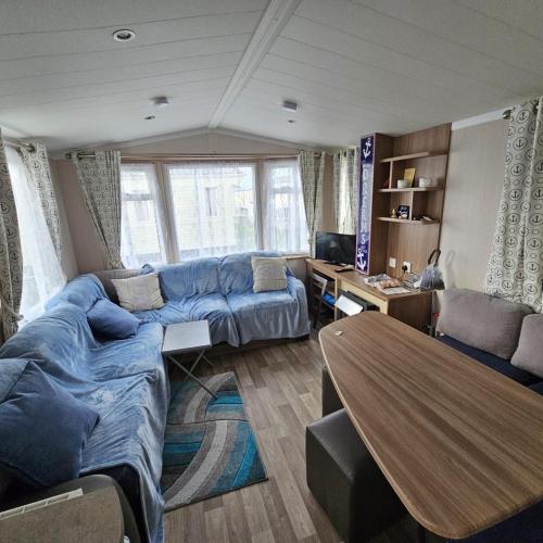 a living room with a blue couch and a table at 2BEDROOMEVIE in Rhyl