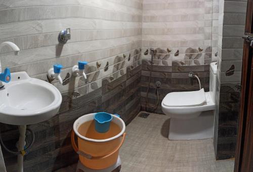 La salle de bains est pourvue d'un lavabo et de toilettes. dans l'établissement Tribhuvan Residency, à Ujjain