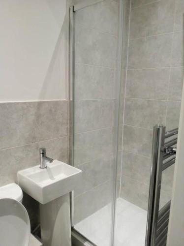 ein Bad mit einer Dusche, einem Waschbecken und einem WC in der Unterkunft Ensuite double-bed (G1) close to Burnley city centre in Burnley