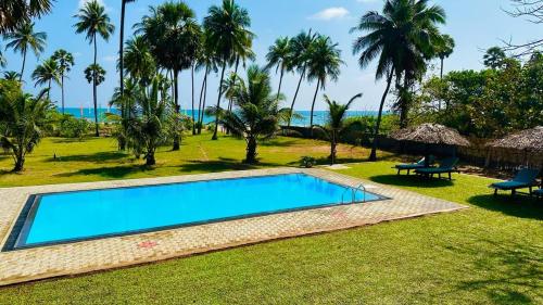 a swimming pool in a resort with palm trees at 108 Palms Beach Resort in Trincomalee