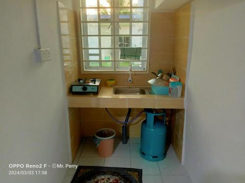 Una pequeña cocina con fregadero y ventana. en SP 3 Homestay Kuranji Kota Marudu Sabah Malaysia, en Kampong Sorosob