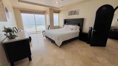 a bedroom with a large bed and a large window at Beautiful Beach Front Condo near Downtown in Rosarito