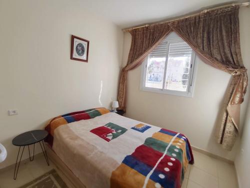 ein kleines Schlafzimmer mit einem Bett und einem Fenster in der Unterkunft Maison de vacances in Ifrane