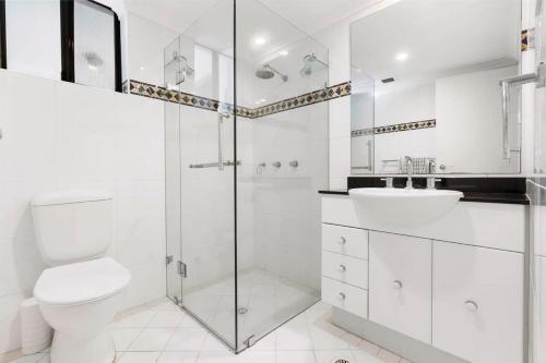 a white bathroom with a toilet and a sink at Walking Distance to Darling Harbour in Sydney