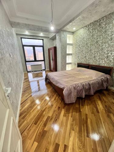 um quarto com uma cama grande e piso em madeira em London House Apartment em Baku