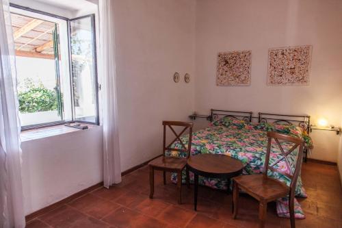 サンターガタ・ディ・ミリテッロにあるLa Villetta Eolianaのベッドルーム1室(ベッド1台、テーブル、窓付)