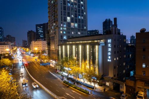 a city street at night with buildings and lights at Nostalgia S Hotel Kunming Old Street 时光漫步S酒店 昆明火车北站穿心鼓楼地铁站店 Free fresh ground coffee,Free laundry service in Kunming