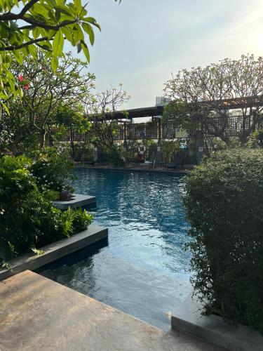 a swimming pool with blue water and trees at Circle condominium in Makkasan