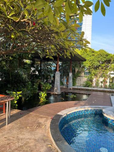 Circle condominium في Makkasan: مسبح في حديقة فيها مظلة