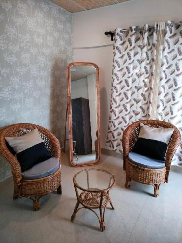 sala de estar con 2 sillas y espejo en Pratishruti en Guwahati