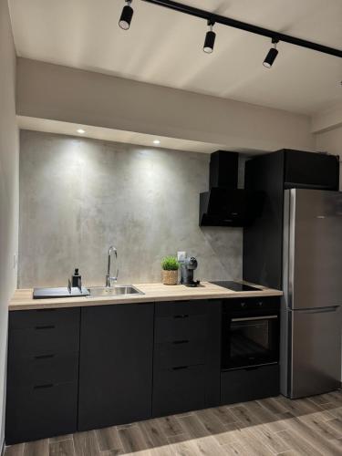 a kitchen with a sink and a refrigerator at Artemis Apartments in Diakopto