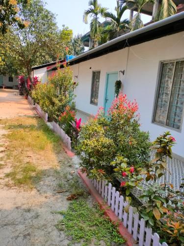 una casa blanca con flores y una valla en Pratishruti en Guwahati