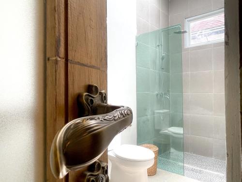 La salle de bains est pourvue de toilettes et d'une douche en verre. dans l'établissement La PAYANA House Penida, à Toyapakeh