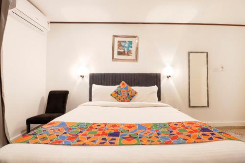a bedroom with a bed with a colorful quilt on it at FabHotel Park Inn Indiranagar in Bangalore
