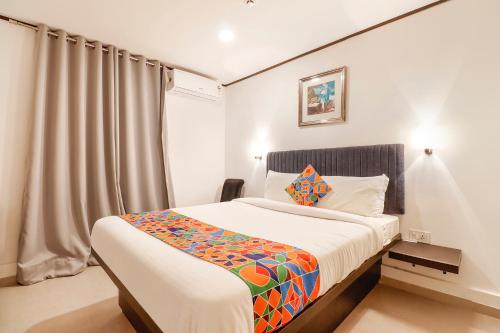 1 dormitorio con 1 cama con una manta colorida en FabHotel Park Inn Indiranagar en Bangalore