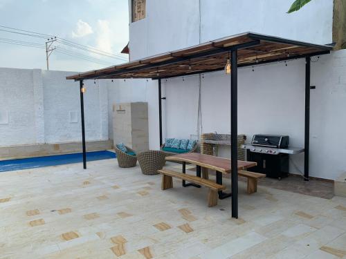 a pavilion with a wooden bench and a table at Hermosa Casa Central - Rositas's house in La Mesa