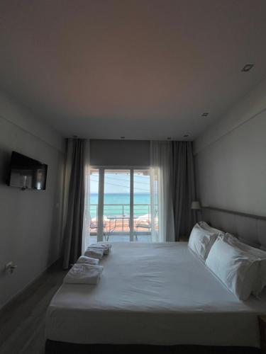 een slaapkamer met een bed en uitzicht op de oceaan bij Horizon in Pefkochori