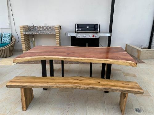 a wooden table and benches in front of a stove at Hermosa Casa Central - Rositas's house in La Mesa