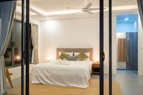 - une chambre avec un lit blanc et un ventilateur de plafond dans l'établissement Modern 3 Bedroom Villa! (KBR16), à Koh Samui 