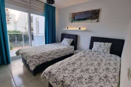 two beds in a room with a window at Scenic Sea View 2BR Apartment * 5min to Beach in Alanya