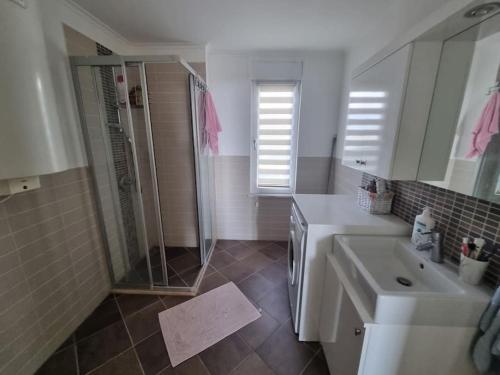 a bathroom with a shower and a sink and a mirror at Scenic Sea View 2BR Apartment * 5min to Beach in Alanya