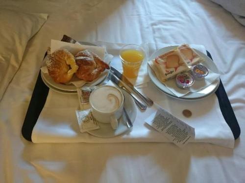 a breakfast tray with two plates of food on a bed at B&B VINTAGE in Vaiano