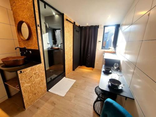 La salle de bains est pourvue d'un lavabo et d'une table avec des verres. dans l'établissement Studio indépendant avec jardin privatif, à Fontenay-aux-Roses