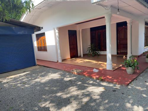 a house with a blue door and a gate at Pinnawala Grand Villa in Rambukkana