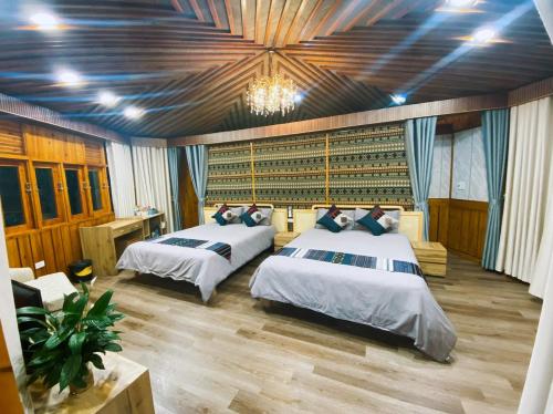 a bedroom with two beds and a chandelier at SaPa Sinai Homestay in Sapa