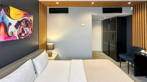 a bedroom with a bed and a painting on the wall at Silver 39 Corner Hotel in Tbilisi City